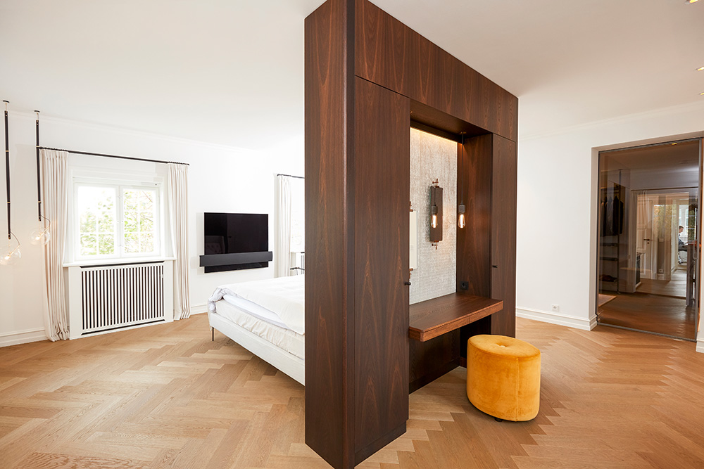 Rumdelingen i soveværelset er specialfremstillet i røget eg og fungerer til den ene side som sengegærde og til den anden side som makeupbord.